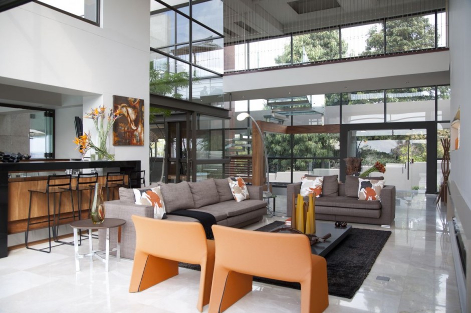 Several glass and marble "bridges" connected by stainless steel cabe, bring together different areas of the house. White marble tiles line the floors of the living area