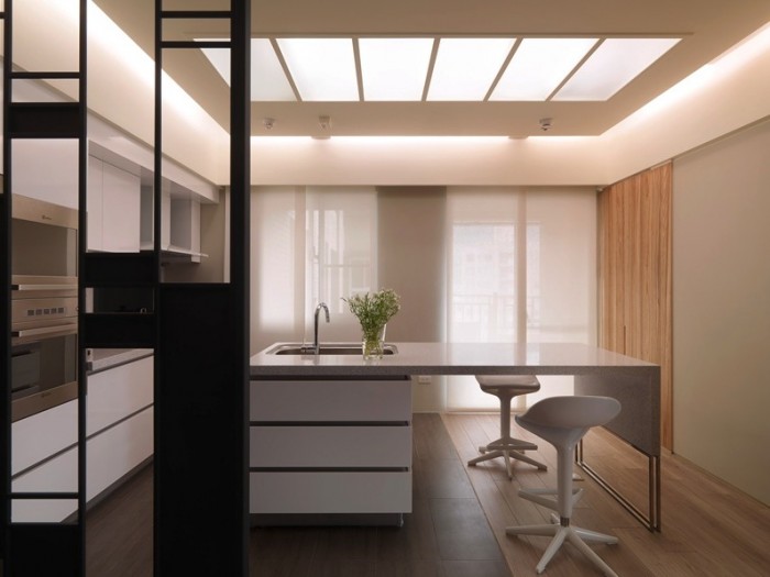 On the other side of the room divider, a slick kitchen also echoes the rectangular design in the simplicity of its handleless drawers and units, and a multi-sectioned skylight.