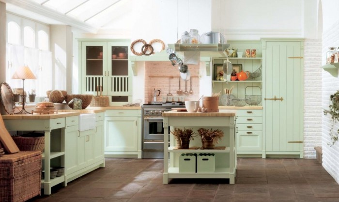 The mint green we see in this kitchen  is quite feminine. While all of the furniture is accented in a farmhouse style with open shelving, paneled doors and brass hardware.