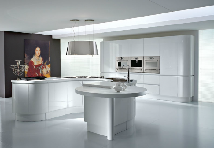 This stunning modern island is as artistic as the portrait hanging beside it. Its curvy lines and sculpted appearance are aesthetically pleasing while its work surface, cooking station and gathering space are functionally attractive.