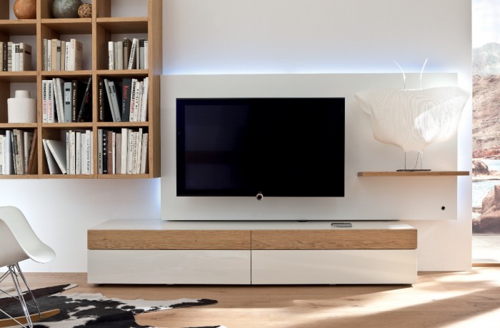 With its simple white finish and light unfinished wood accents, this simplistic media center is accompanied by a wall shelving unit.