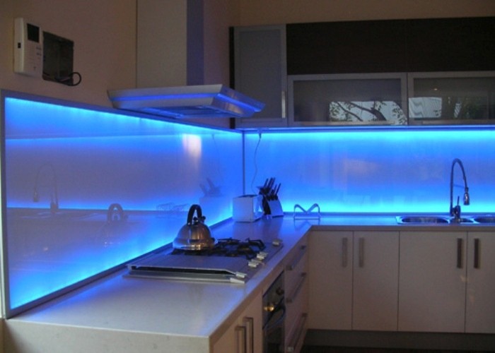 Brilliant blue LED lights add a stunning effect to this glass backsplash.