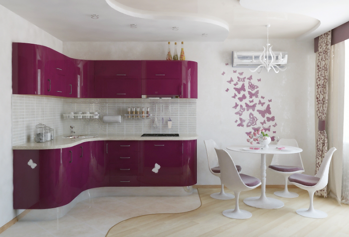 This lovely feminine kitchen in brilliant pink and white features a tiny dining area furnished with small modern furniture.