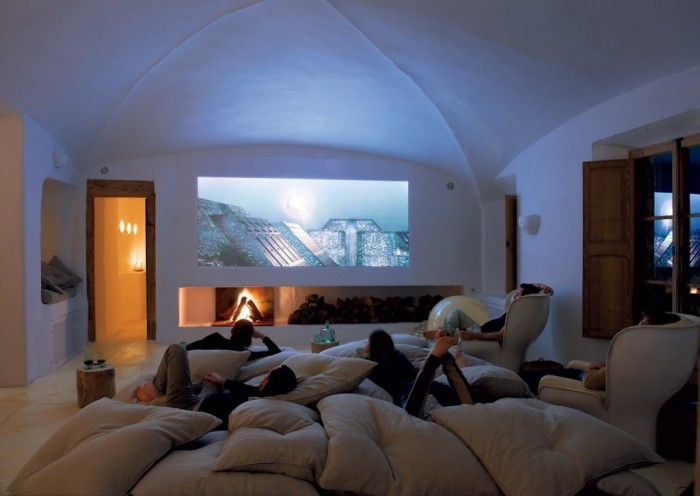 The dome-shaped ceiling opens up this media room basement . The fireplace under the media screen offers ambiance.