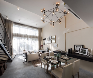 This view shows the open space floor plan with dining area, living area and staircase leading to the second floor.