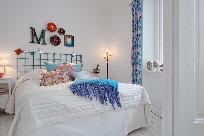 The bedroom is eclectically decorated with bright colors and differing styles for an overall relaxed appeal.