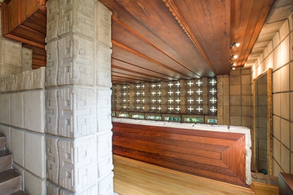 The carved concrete block and wooden aesthetic meanders indoors and is permitted to steal focus in the halls and the mezzanine. Very minimal styling manifests in the occasional mirror to further lengthen the space but the building materials are generally left naked within the interior spaces.