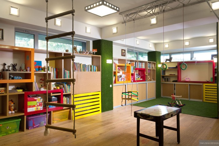 brightly colored childrens playroom with suspended swings and monkey bars