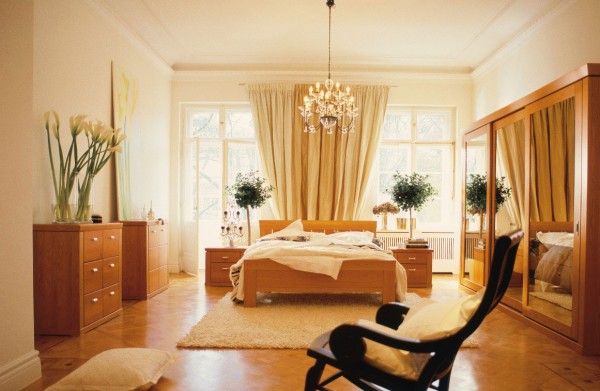 cream chandelier lit bedroom with calla lilies