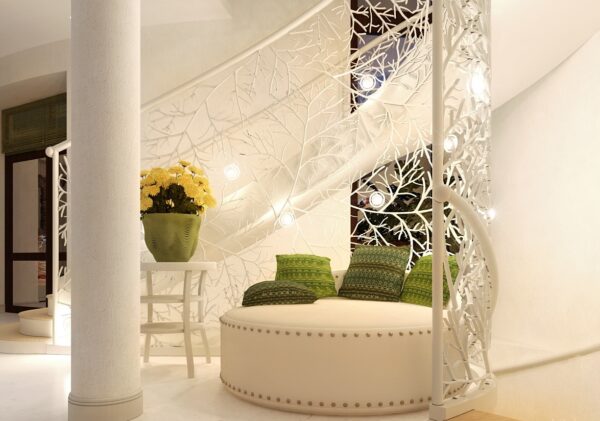 The lovely custom wrought iron stair rail offers a little niche perfect for a round settee.