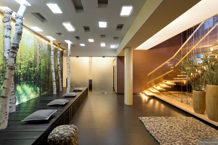 floating stairwell with pillars and glass panels pebble look rug and furnishings and tree trunk feature wall