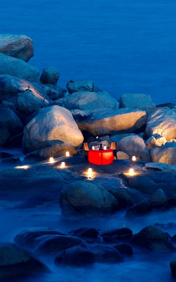 lantern and candle lit dinner on a rocky shore