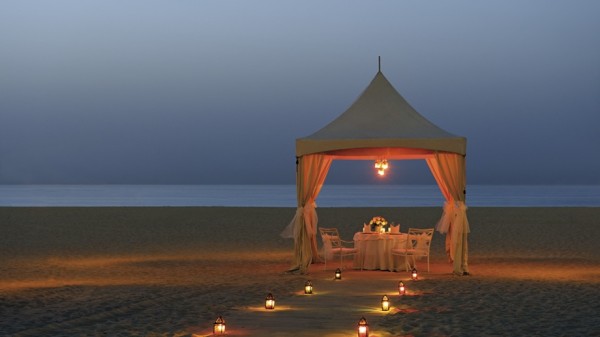 lantern lit beach dinner beneath white gazebo