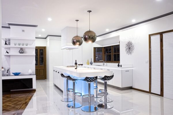 Traditional elements of wood molding, paneled doors and ornate wood flooring mix beautifully with harsher black and white plus metal elements in this modern kitchen.