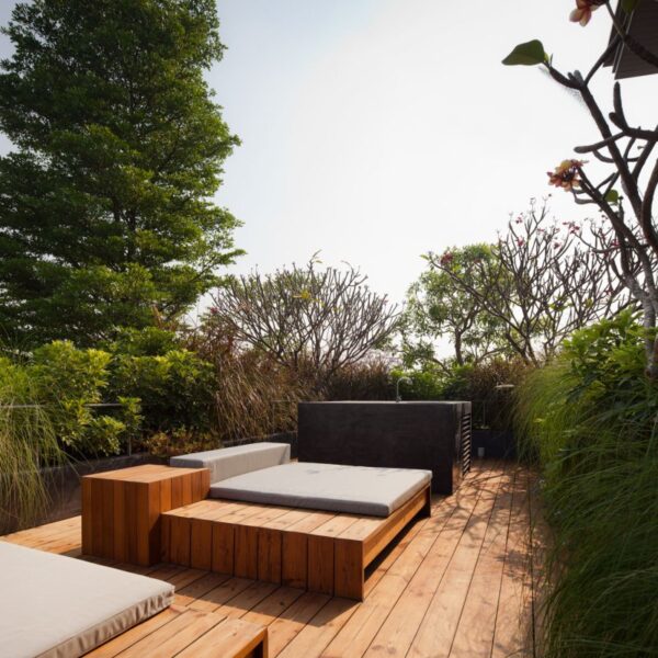 A small private lounge area is set atop a cedar platform and among tall green hedges for privacy.