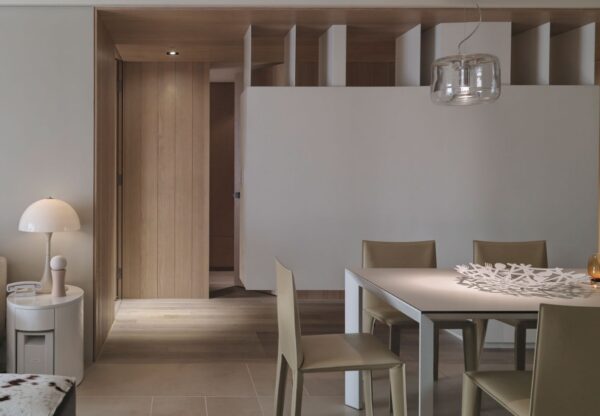 This view of the apartment shows the dining space in the foreground with a glimpse of the bedrooms beyond.