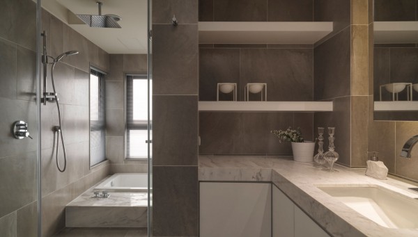 Natural stone tile and marble slabs are used to create a bathroom that offers simple organic luxury.