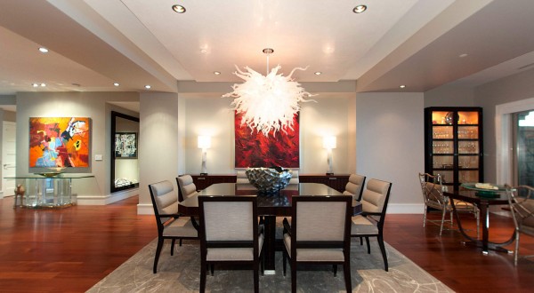 The full dining room sits within an open living space with seating area, piano, and eat-in kitchen.