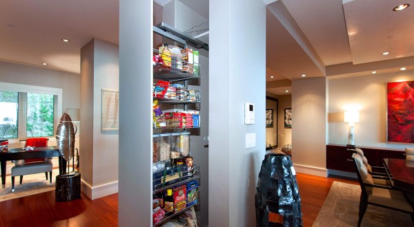 A hidden slide-out pantry fits into a dividing wall in the kitchen.