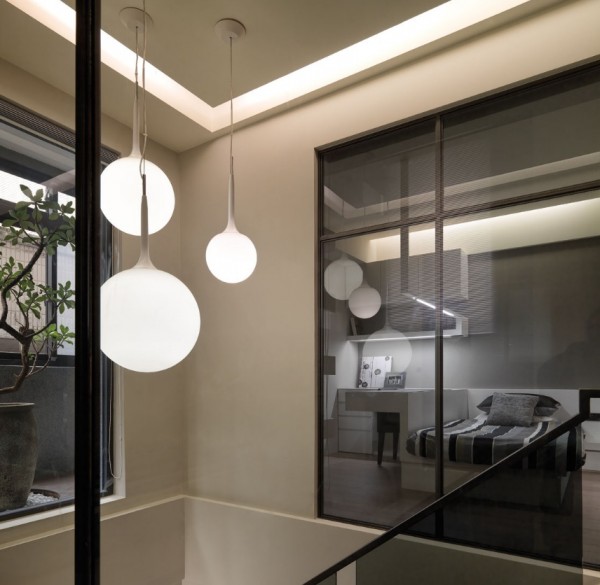 A simple modern opaque globe fixture lights the stairwell from the ceiling of the third level.