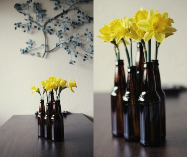 yellow dafodils in recycled beer bottles