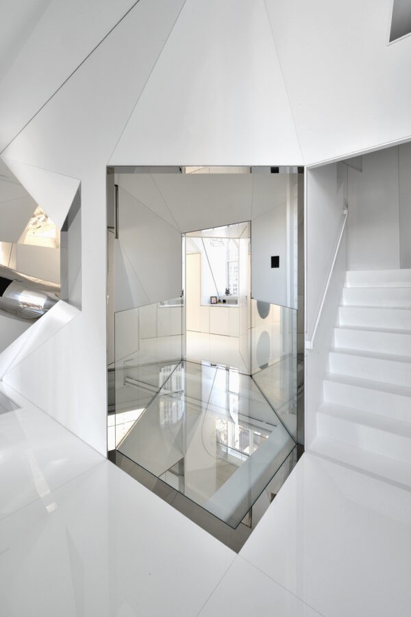 Angular internal stairwell with mezzanine thoroughfare in glass