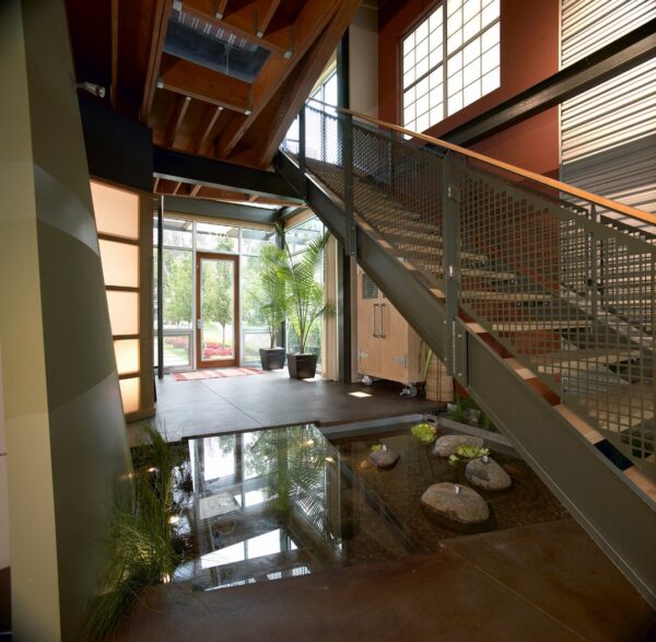 AZD takes the utilization of potentially dead space one step further by adding a glass floor atop the decorative body of water that lies beneath the stairs, creating a thoroughfare that serves as residence's main entry access. This space, like many to follow, is thoughtfully styled with living elements that take the form of water reeds and potted palms, which hints at an underlying ethos of tropical modernism that is seen in greater detail throughout this collection.