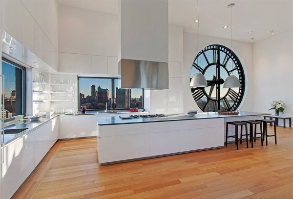 Clock Tower Apartment- glossy white open plan kitchen with island range and wood flooring