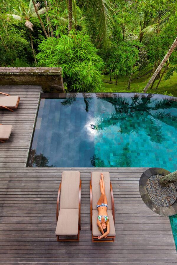 Como Shambhala Estate Bali- deckchairs and infinity pool with bamboo and palm forest views