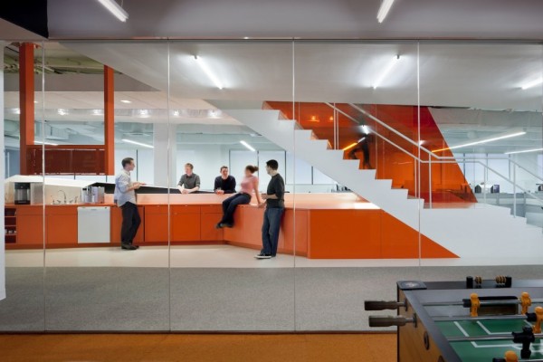 The glass-paneled staircase, in particular, fosters a hive of activity. Upon their descent, employees arrive at a coffee bar, which spans thirty feet and acts as the centrally located heart for Kayak's various departments.