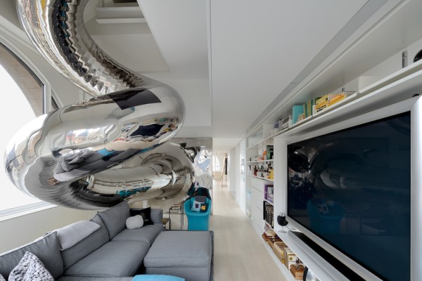 Metallic tubular slide exit into living entertainment in white and grey