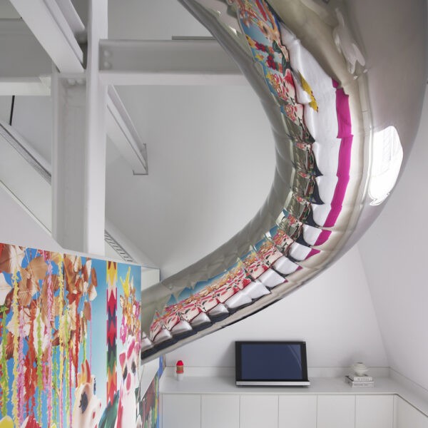 Metallic tubular slide passing through bedroom with reflection