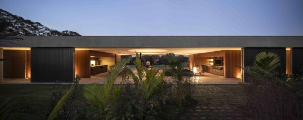 Marcio Kogan's Casa Lee Concrete House- exterior in the evening entrance with palms