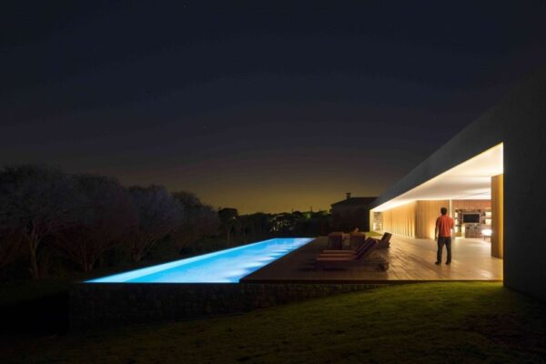 Marcio Kogan's Casa Lee Concrete House- pool at night with wooden decking