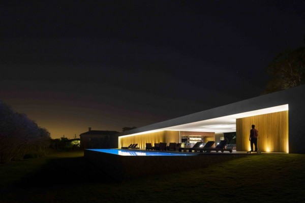 Marcio Kogan's Casa Lee Concrete House- view of exterior and pool at night