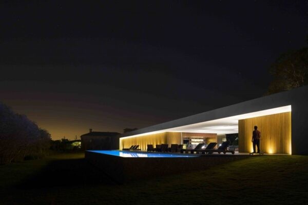 Marcio Kogan's Casa Lee Concrete House- view of exterior and pool at night