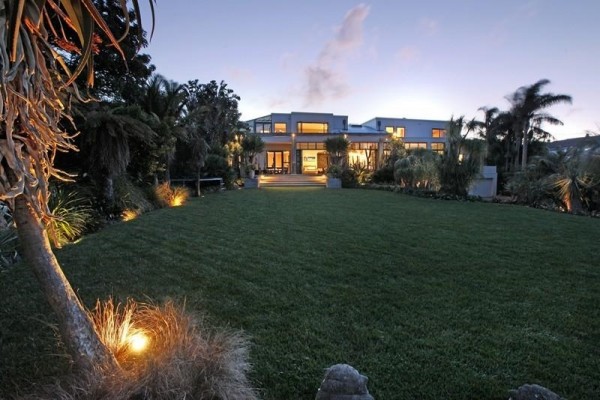 Sotheby's Auckland House- tropical garden lush lawn leading to house exterior
