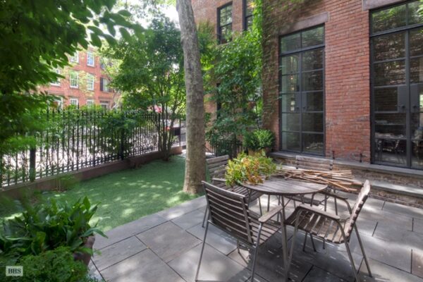 The backyard of Ms. Lebovitz's townhome is small yet intimate with a simple slat-wood table and chairs.