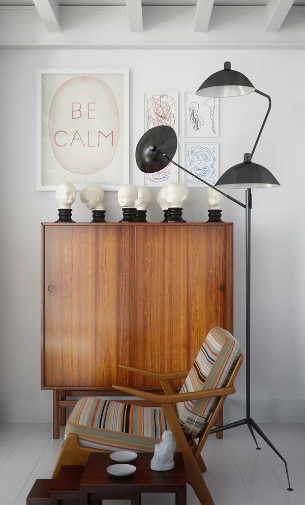 A pairing of a classic Danish modern chair and cabinet in rich wood add warmth to the otherwise stark white space.