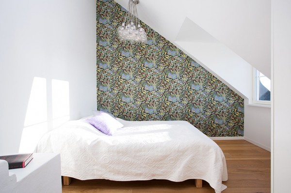 This understated bedroom gets a punch of color and pattern from a chaotic modern papered wall.