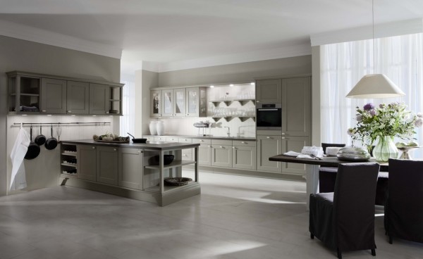 In a departure from a sleek façade that has not the need for handles, the cabinets featured in this image are altogether more reminiscent of a French farmhouse kitchen, albeit still a modern interpretation. The choice in flooring supports the exposed industrial display of the kitchen utensils, which hang atop a meeting of worktop and wall. It is interesting that Leicht has decided not to isolate the worktop in the typical kitchen island fashion, but viewers will notice the openness and sizable impression of the space, just as they will, the way in which this allows the honest flooring material to be showcased in its best light.