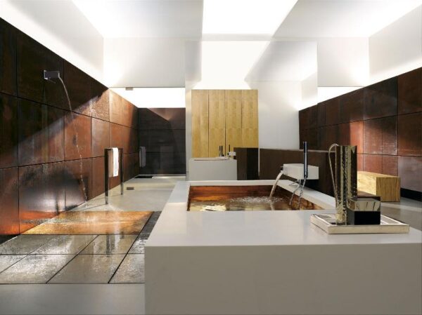 Brilliant patinaed copper highlights the shower floor and interior of the large soaking tub in this modern bathroom. Other warming elements come from the wood paneled walls and natural light streaming from skylights.