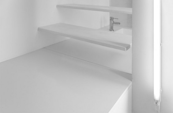 The kitchen sink can be seen through the stair risers which are lit by florescent bulbs from the side.