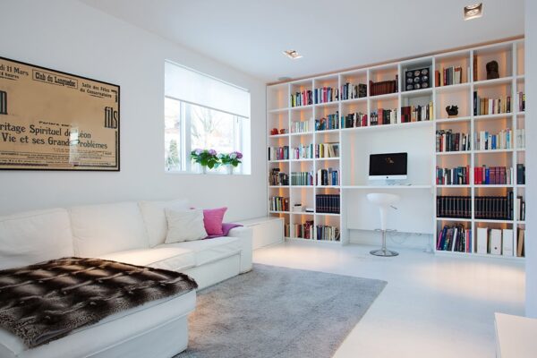 The family room with built-in library and work station allows for many leisurely and work-related pursuits. The book shelves boast a lovely backlit feature that highlight the colorful book collection.