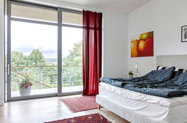 Modern Villa Level 2 Bedroom 1 One of the villa's bedrooms provide views to the countryside beyond a large sliding door spanning from ceiling to floor. Red sheers add a nice touch of color to the space as does the art print and rugs.