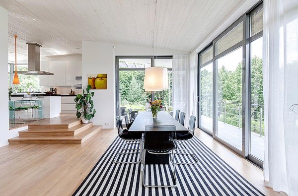 Dynamic black and white is the order of the day in the light filled dining space. In the large open space, the dining area is defined by a dramatic stripe rug under the dining table.