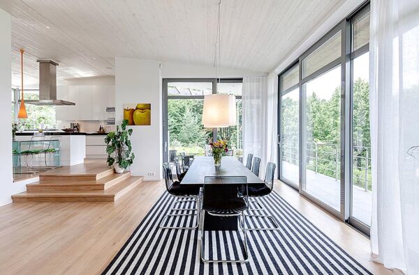 Modern Villa Dining Room 1 Dynamic black and white is the order of the day in the light filled dining space. In the large open space, the dining area is defined by a dramatic stripe rug under the dining table.