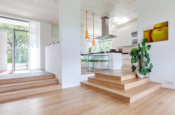 The elevated kitchen floats above the dining room in an open plan layout allowing light and air to flow throughout the space.