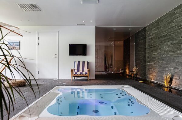 Modern Villa Interior Spa 1 A jacuzzi pool for six provides more than enough room to stretch out and relax. A shallow water feature runs the length of the wall providing a natural element.