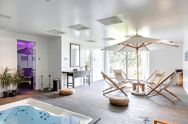 Modern Villa Interior Spa 2 Who says umbrellas are for the outdoors only? This home spa boasts a natural wood and canvas fabric version. The sauna on the far wall is illuminated in a dramatic purple.
